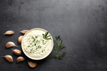 Tasty sauce with garlic in bowl on table