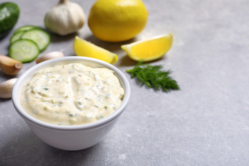 Tasty sauce with garlic in bowl on table