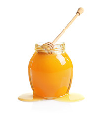 Glass jar with delicious honey and dipper on white background