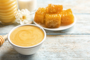 Bowl with delicious honey on table, closeup