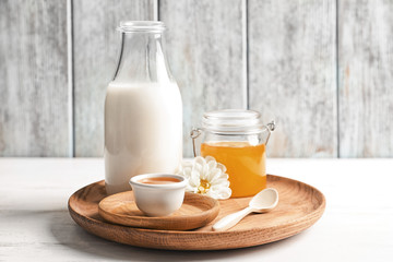 Fototapeta na wymiar Wooden dish with milk and honey on table