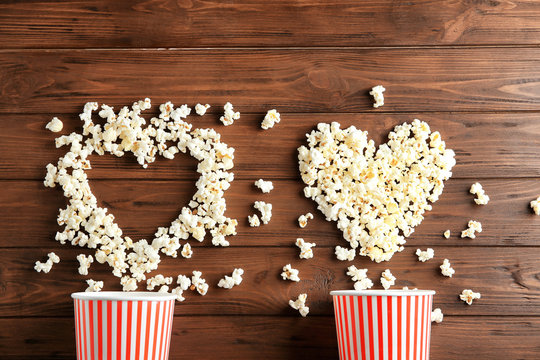 Composition with tasty popcorn on wooden background, top view