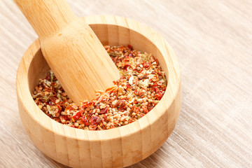 spices and mortar on wood background