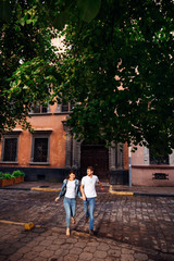 Fototapeta na wymiar Couple holding hands and running on the pavement. Fun. love, rel