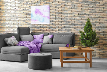 Modern living room interior with comfortable couch and grey ottoman