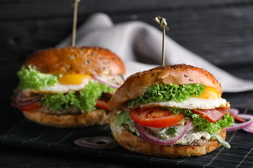 Tasty burger with fried egg on table, closeup