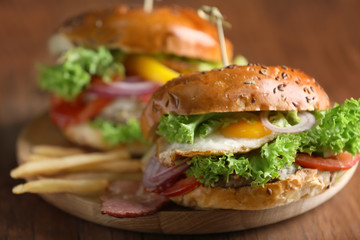 Tasty burger with fried egg on table, closeup