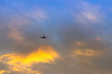 Fototapeta na wymiar Commercial airplane flying at sunset sky
