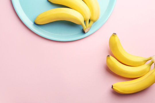 Composition with ripe bananas on color background