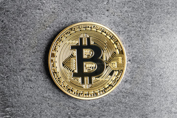 Golden bitcoin on grey background