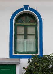 Blended bow window in a white building with green and blue paint, outdoors, Puerto de Mogan, Gran Canaria in Spain