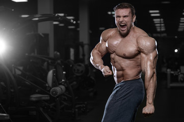 Naklejka na ściany i meble Brutal strong bodybuilder athletic men pumping up muscles with dumbbells.