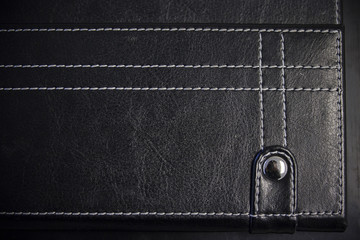 A leather stitched background with a button