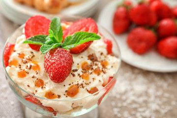 Bowl of yummy dessert with caramel and strawberry, closeup