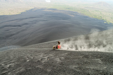 CERRO NEGRO, NICARAGUA - APRIL 26, 2016: Tourist is volcano boarding from Cerro Negro volcano,...