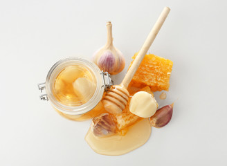 Composition with honey and garlic as natural cold remedies on white background, top view