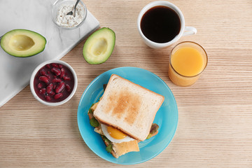 Composition with tasty toasts and fried egg on wooden table