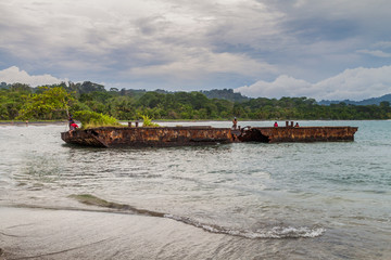 PUERTO VIEJO DE TALAMANCA, COSTA RICA  - MAY 16: People on a rusty pontoon in Puerto Viejo de Talamanca village, Costa Rica