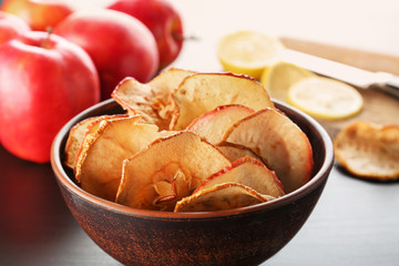 Bowl with tasty apple chips on table