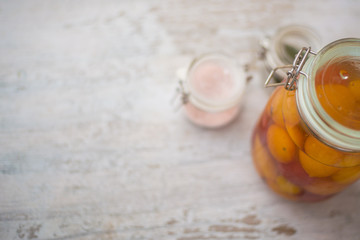 Fruits, glass jars, leaves and spices on a rustic white wooden table. Concept of healthy, natural food. Copy space for text.