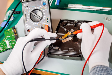 man repairing hard drive in service center. Repairing and fixing service in lab. Electronics repair service concept.