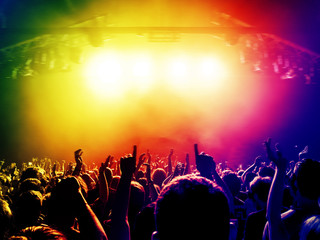 Fototapeta na wymiar Concert people dancing in colorful stage lights