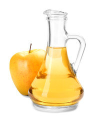 Glass jug with apple vinegar and fresh fruit on white background