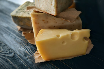 Different kinds of delicious cheese on table