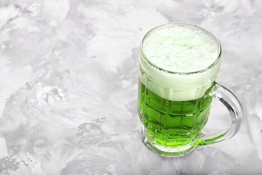 Glass of green beer on grey background. Saint Patrick's day celebration