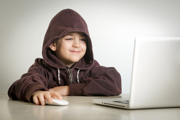 Young boy with smiley face in front of laptop 