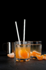orange drink, tangerines and lemon on a dark background