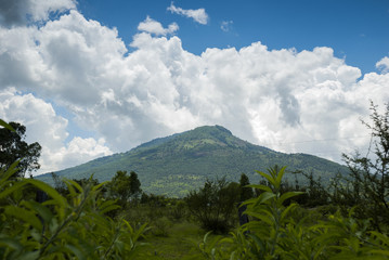 Summer landscape with mountains, cloudy sky, green grass and trees in Guatemala.