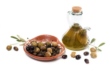 Green and black olives with olive oil bottle
