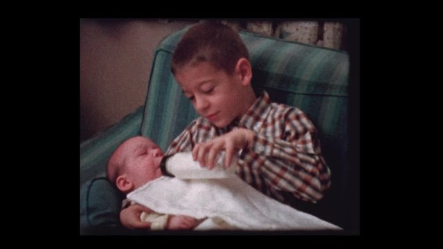 1959 7 year old boy give bottle to infant baby brother