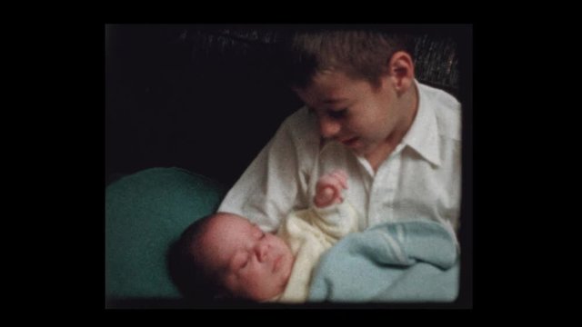 1959 7 year old boy holds infant baby brother for 1st time