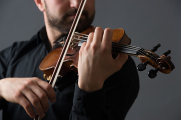 Musician man playing the violin. Musical instrument on performer hands. Classic music concept.