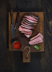 grilled steak  on a cutting board on a wooden background