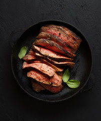 grilled steak in a frying pan on a wooden background