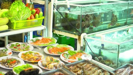 Wide choice of seafood in aquariums in the night market in Vietnam. Rawai fish market. Closeup view of alive sea inhabitants in special containers with water.