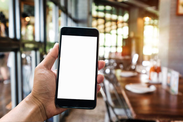 A woman hand holding smart phone device in the coffee shop or cafe background.
