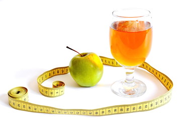 measuring tape, glass of freshly squeezed orange juice and green apple isolated on white background 