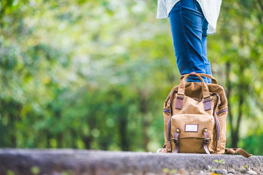 Close Up Backpack Of Woman Backpacker Standing On Countryside Road With Tree In Spring Green Seasonal,Alone Travel Or Single Traveller Concept..