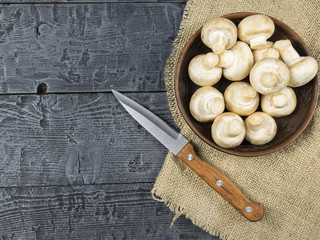 Fresh mushrooms with leaves parsley on a rustic wooden table. Vegetarian food is on the table. The view from the top.