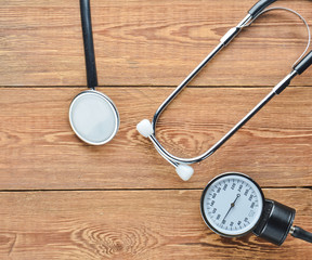 Cardiological medical equipment for measuring pressure on a wooden table. Stethoscope and measure...