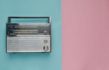 Retro radio receiver on a pink blue pastel background. Media technology 60s. Top view.