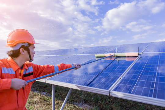 Electrical and instrument technician wash and cleaning solar panel at solar plant field