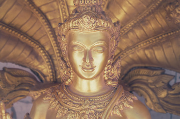 Close up of a golden buddha. Toned image with a vintage effect look.
