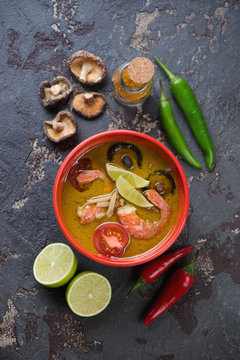 Spicy thai green curry soup on a brown stone background, vertical shot, top view