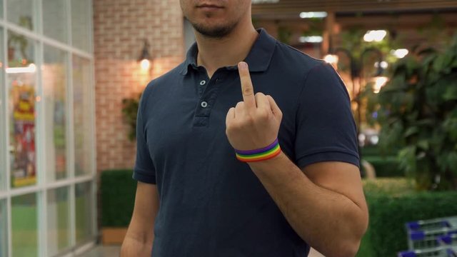 a man with a lgbs symbolism, shows the middle finger