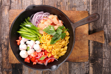 raw pasta and ingredient on pan